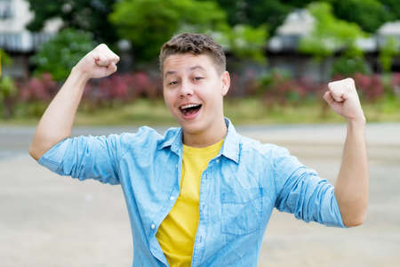 Happy cheering german young adult man outdoor in cityの写真素材