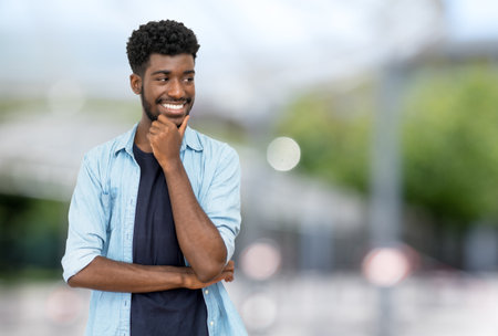 Hipster man from Africa with beard and casual clothes outdoor in city in summerの写真素材