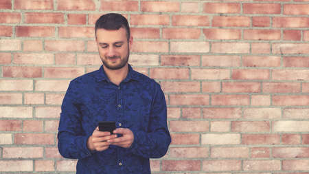 Fashionable british man sending message to girlfriend with monile phoneの写真素材