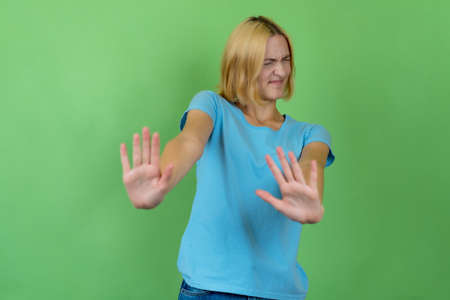 Young woman with colored blond hair gesturing stop and distanceの写真素材