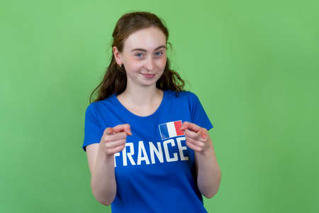 Happy french female soccer supporter isolated on green backgroundの写真素材