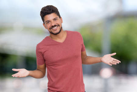 Laughing latin american man with beard outdoor in summer in cityの写真素材