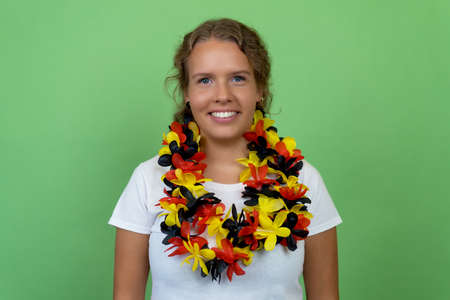 Beautiful german female soccer fan isolated on green background for cut outの写真素材