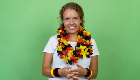 Pretty german female soccer fan isolated on green background for cut outの写真素材