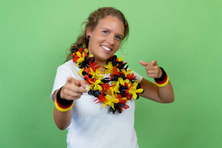 Laughing german female soccer fan isolated on green background for cut outの写真素材