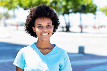 Happy african american woman in city in summerの写真素材