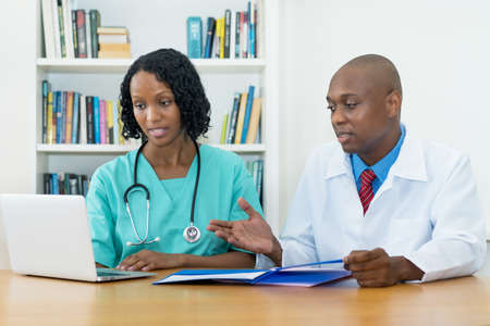 African american medical team working at computer at desk at hospitalの写真素材