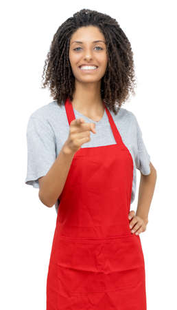 Laughing waitress or female clerk with curly hair and red apron isolated on white background for cut outの写真素材