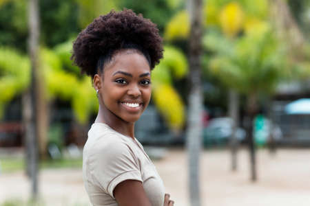 Pretty caribbean woman with afro hair outdoor in summer in cityの写真素材