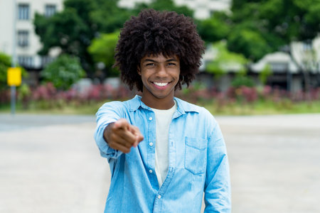 Handsome african american male young adult with afro haistyle outdoor in summer in cityの写真素材