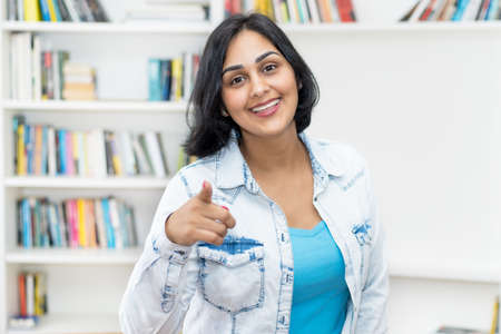Happy laughing mature adult hispanic woman indoors at homeの写真素材