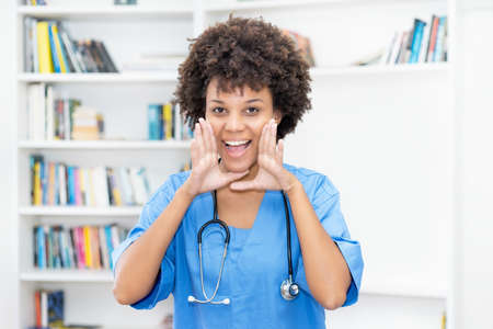 Beautiful afro american female nurse ready for vaccinating patients at hospitalの写真素材