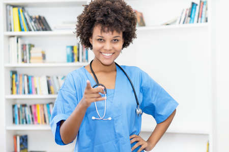 Laughing afro american female nurse ready for vaccinating patients at hospitalの写真素材