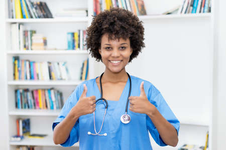 Pretty afro american female nurse ready for vaccinating patients at hospitalの写真素材