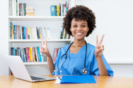 Laughing and motivated afro american nurse or doctor at work at hospitalの写真素材