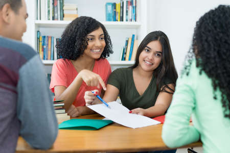 Group of mexican male and female students learning together at classroom of collegeの写真素材