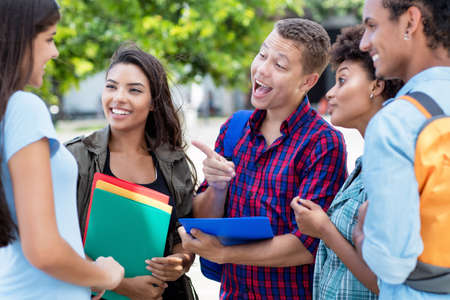 German exchange student talking with multi ethnic young adults outdoor in summer in cityの写真素材