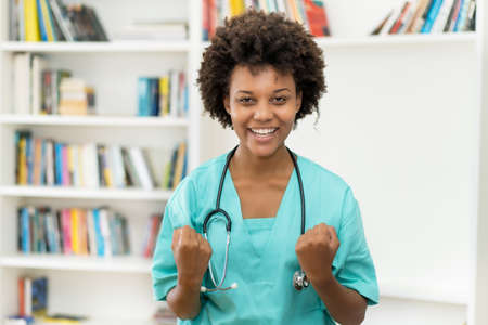 Cheering afro american female nurse at work at hospitalの写真素材