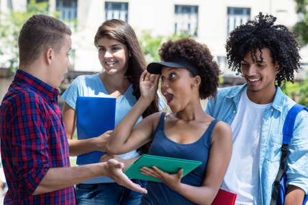 Learning and talking multi ethnic male and female students outdoor in summer in cityの写真素材