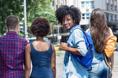 Joyful laughing mexican male student with group of multi ethnic young adults outdoor in summer in cityの写真素材