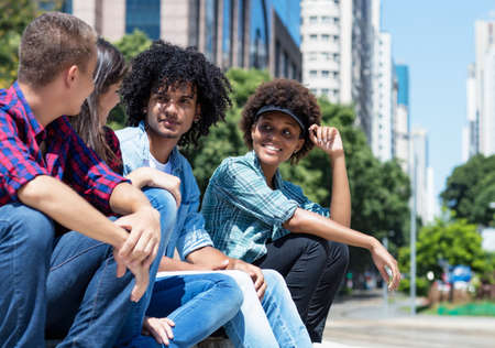 Group of talking young adults outdoor in summer in cityの写真素材