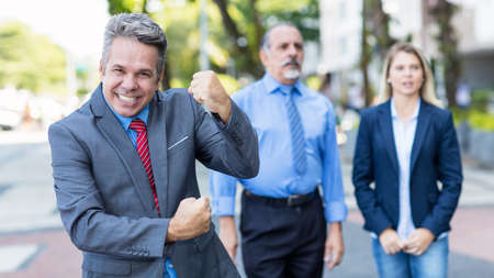 Cheering German mature businessman with colleaguesの写真素材