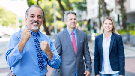 Cheering mexican senior businessman with colleaguesの写真素材