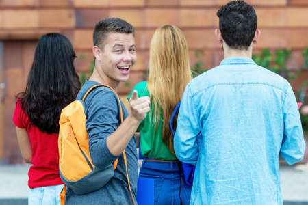 Laughing german male student with group of other students at campus of universityの写真素材