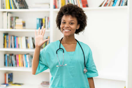 Greeting afro american female nurse at work at hospitalの写真素材