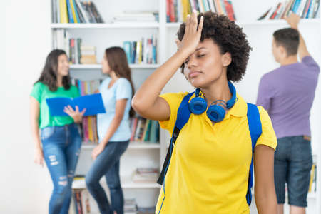 Beautiful afro american female student with hand on head as symbol for failure at classroom of universityの写真素材