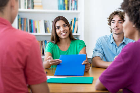 Laughing male and female students learning for test at classroom of universityの写真素材