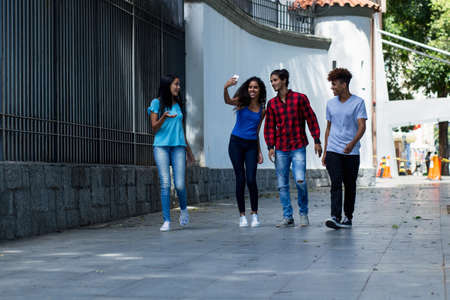 Happy group of brazilian and mexican hipster young adults in city in summerの写真素材