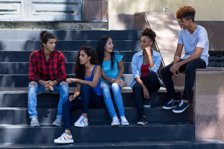 Group of latin american and hispanic young adult immigrants hanging out in city in summerの写真素材