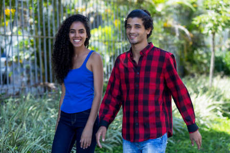 Brazilian hipster couple walking in city in summerの写真素材