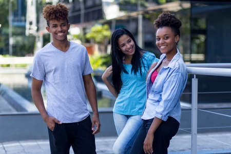Young latin and hispanic and african american hipster people outdoors in city in summerの写真素材