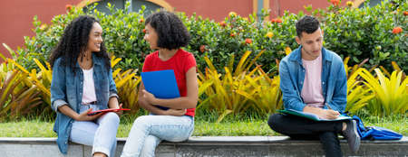 Small group of latin american students learning and talking at campus of universityの写真素材