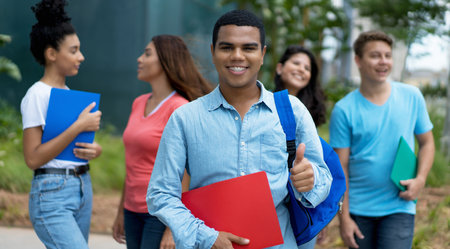 Successful brazilian male student with braces and group of multi ethnic young adults outdoor in cityの写真素材