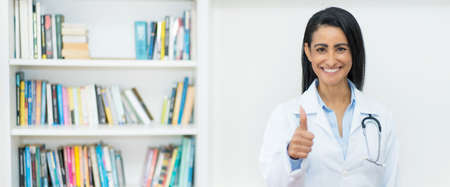 Optimistic mexican female doctor with copy space at clinicの写真素材