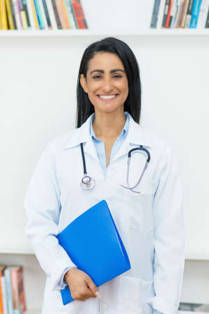 Laughing mexican female doctor with copy space at clinicの写真素材