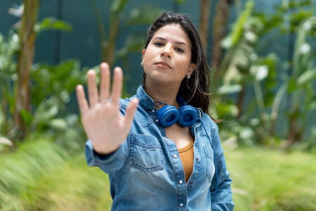 Caucasian female young adult gesturing stop and distance in summerの写真素材