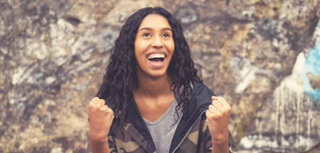 Cheering south american hipster woman in urban styleの写真素材