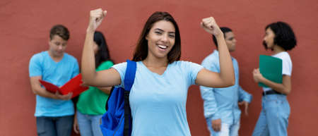 Cheering mexican female student with group of multiethnic students outdoors in summerの写真素材