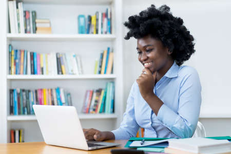 African american student or business trainee at video call at desk at officeの写真素材