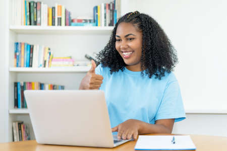 Video call of latin american female student at desk indoors at homeの写真素材