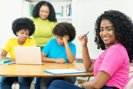 Pretty african american computer science student with group of coding students at universityの写真素材