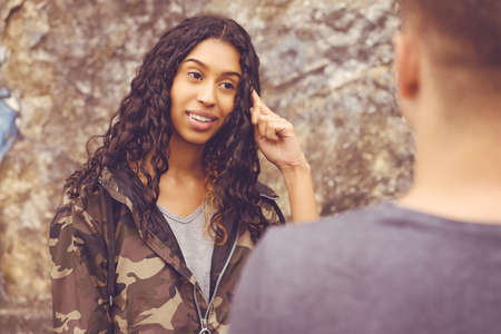 Smart south american hipster woman talking with boyfriend outdoor in urban styleの写真素材