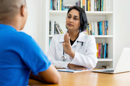 Hispanic female doctor talking about cancer with patientの写真素材