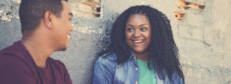 Laughing corpulent african american woman talking with boyfriend outdoor in urban city styleの写真素材