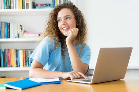 Young caucasian female student learning at computer at desk at universityの写真素材