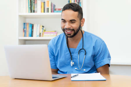 Handsome latin american medical student at computer at hospitalの写真素材